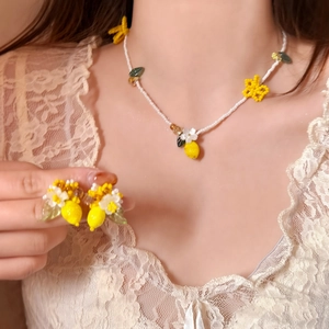 Detail shot of a sweet handmade lemon and flower resin jewelry set for beach vacation