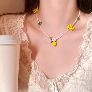 Sweet handmade beaded necklace featuring yellow resin flowers and lemon pendants on a model