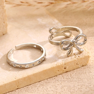 Detail of silver alloy ring set with bow design and butterfly engraving on stone