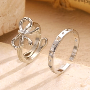 Detail of silver vintage bow ring and butterfly engraved band on stone tray