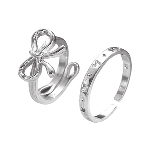 Detailed view of silver bow-shaped adjustable ring set with butterfly engravings