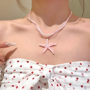 Close-up of a sweet pink resin starfish pendant necklace with a sheer pink ribbon cord