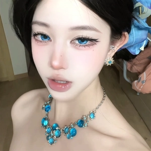 Primo piano dettagliato di un'elegante collana floreale in cristallo blu su modella
