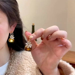 Close-up detail showing the sweet brown zircon flower drop earrings on a model