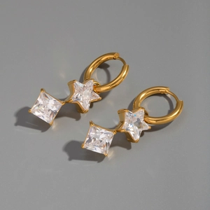 Macro detail of 18K gold-plated star and square zircon pendant earrings in deep gray setting