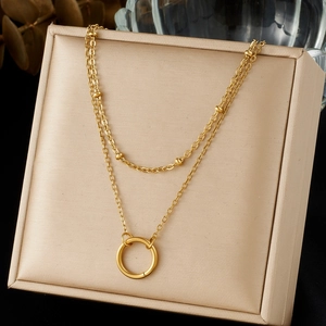 Double-layered gold stainless steel necklace featuring small beads and a round ring pendant