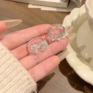 Detail view of silver bow rings with pearls and sparkling cubic zirconia
