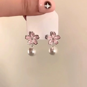 Detail view of pink petal flower earrings with elegant white pearl drops for women