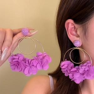 Detailed close-up shot of large purple fabric flower hoop earrings worn by an Asian model