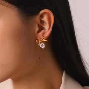 Detailansicht eines goldenen Schleifenohrrings mit einem funkelnden herzförmigen Zirkonia