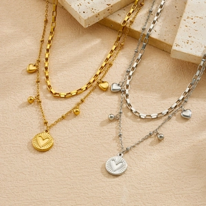 Detailed view of gold and silver stainless steel layered necklaces with heart pendants.