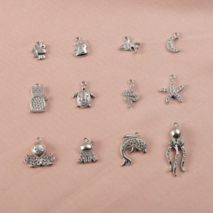 Vue détaillée de pendentifs animaux en acier inoxydable argenté avec des strass brillants.