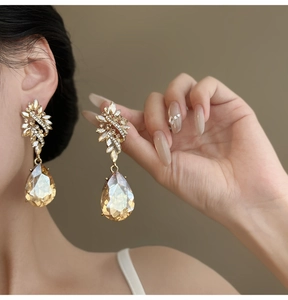 Detailed close-up of Baroque vintage gold earrings featuring large champagne crystal teardrops.