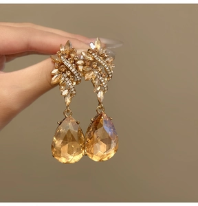 Detailed view of vintage Baroque style floral earrings featuring large amber teardrop crystals