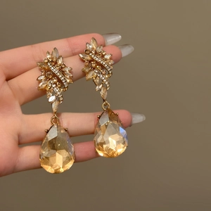 Detailed view of vintage baroque gold earrings with champagne water drop crystals.