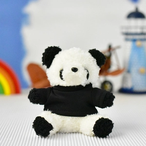 Detailed view of a fluffy panda plush toy wearing a miniature black t-shirt accessory