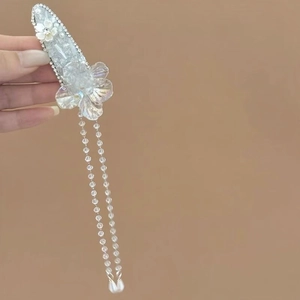 Detailed view of an elegant crystal flower hair clip with long sparkling beaded tassels