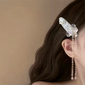 Detailed view of an elegant crystal flower hair clip with long beaded tassels for women