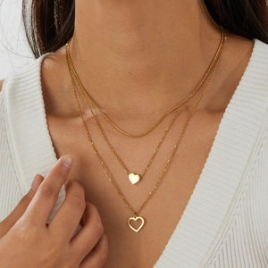 Close-up of three-layer gold stainless steel necklace with heart pendants on model