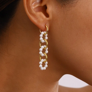 Detail of 18K gold-plated hoop earrings with cascading white pearls on a female model