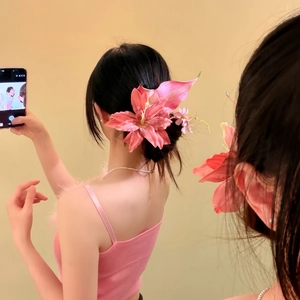Close-up of an oversized pink flower hair clip for a spring seaside vacation style