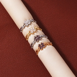 Detalle de cuatro anillos en forma de trébol con circonitas de colores en un expositor.