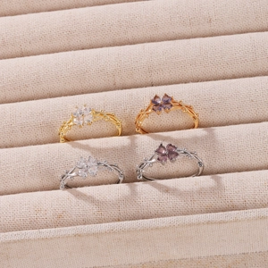Vista detallada de cuatro anillos de flores en oro y plata con piedras de circón