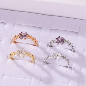 Selección de anillos de trébol de cuatro hojas con cristales morados y claros en caja