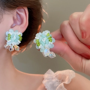 Close-up of handmade beaded flower earrings with iridescent crystal tassels