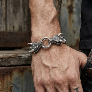 Vista dettagliata di un bracciale con testa di drago in acciaio al titanio su polso maschile.