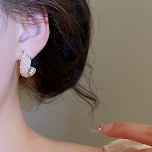 Detaillierte Nahaufnahme von silbernen Ohrsteckern mit rosa Kristallen am Modellohr