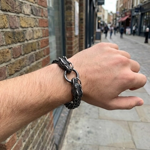 Detail of vintage dragon head steel bracelet with thick curb chain and round clasp