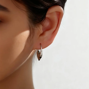 Close-up of S925 sterling silver heart-shaped hoop earrings worn by a model