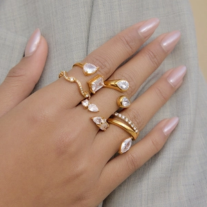 Close-up of gold stainless steel open rings featuring various clear zircon stones