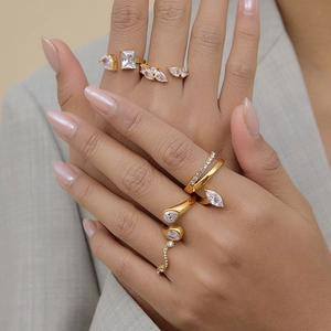 Detail shot of multiple gold-plated stainless steel open rings with white zircon stones