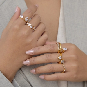 Close-up detail of gold plated titanium steel open rings with clear cubic zirconia stones