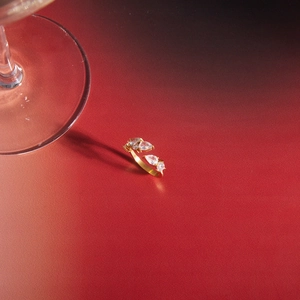 Detail of gold titanium steel open ring featuring sparkling pear-shaped zircons