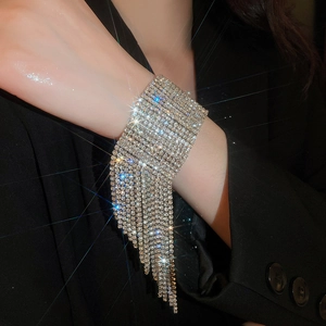 Detailansicht eines funkelnden mehrlagigen Strass-Manschettenarmbands mit Fransen