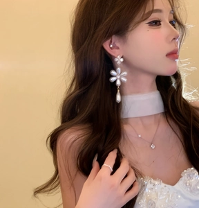 Elegant French style flower pearl dangle earrings shown on a model from a side profile view.