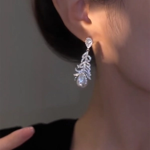 Elegant silver feather earrings with micro-pave zirconia and a lustrous pearl drop