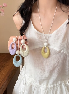 Minimalist colorful oval textured pendant necklace set in pastel tones shown on model