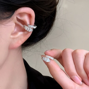 Detailed view of an elegant silver snake-shaped zircon ear cuff worn by a model