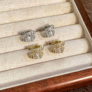 Exquisite snake-shaped zircon ear cuffs in gold and silver finishes displayed in a wooden jewelry box