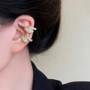 Detailed view of luxury gold snake-shaped ear cuffs set with pavé zircon stones