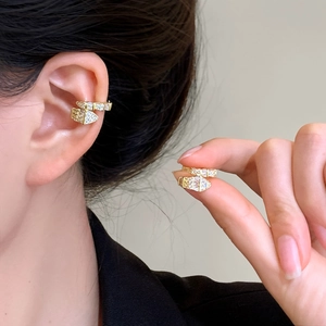 Close-up of an elegant gold-plated snake ear cuff adorned with sparkling zircon stones.