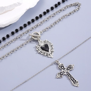 Gothic multi-layer necklace set with heart toggle pendant and cross on a purple background