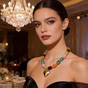 Primo piano dettagliato di una collana di perline in resina con un cuore d'oro lucido.