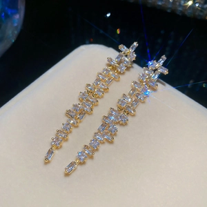 Makroansicht eleganter 18 Karat vergoldeter Quastenohrringe mit quadratischen Zirkonia-Steinen