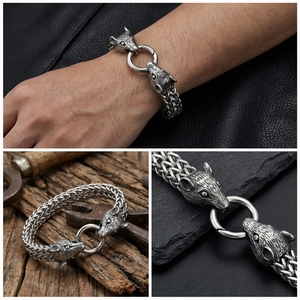 Close-up of vintage wolf head stainless steel braided bracelet for men on leather background
