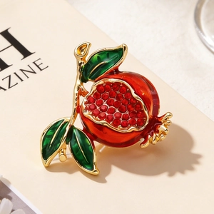 Nahaufnahme-Detail der Granatapfel-Brosche mit roten Emaille-Samen und Gold-Finish